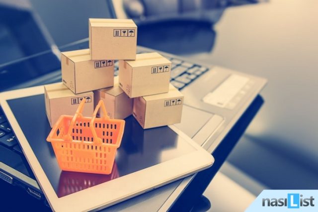 Mini orange shopping basket on a smart device and a laptop with boxes. Concept of shopping that client can buy or purchase goods or products from websites worldwide via internet by just a few clicks.